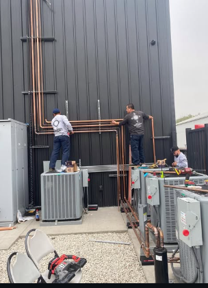 Original Zia Degrees jobsite photo showing technicians installing copper lines and HVAC equipment